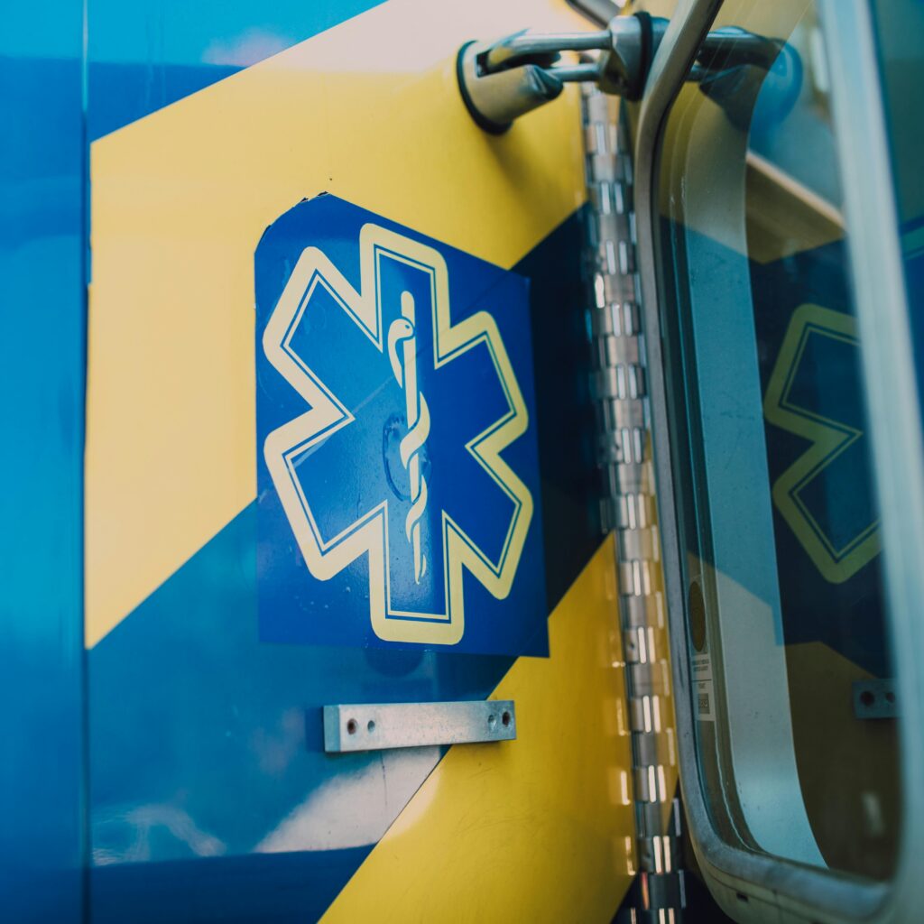 Vibrant blue and yellow medic symbol on an ambulance door, representing emergency medical services.