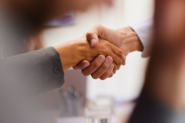 close up of unrecognizable business colleagues shaking hands in the office.